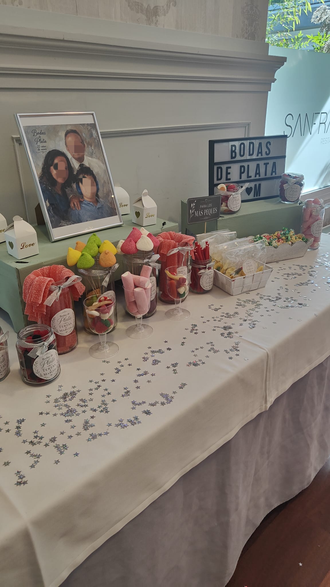 Mesa de chuches con tarros de cristal y etiquetas personalizadas