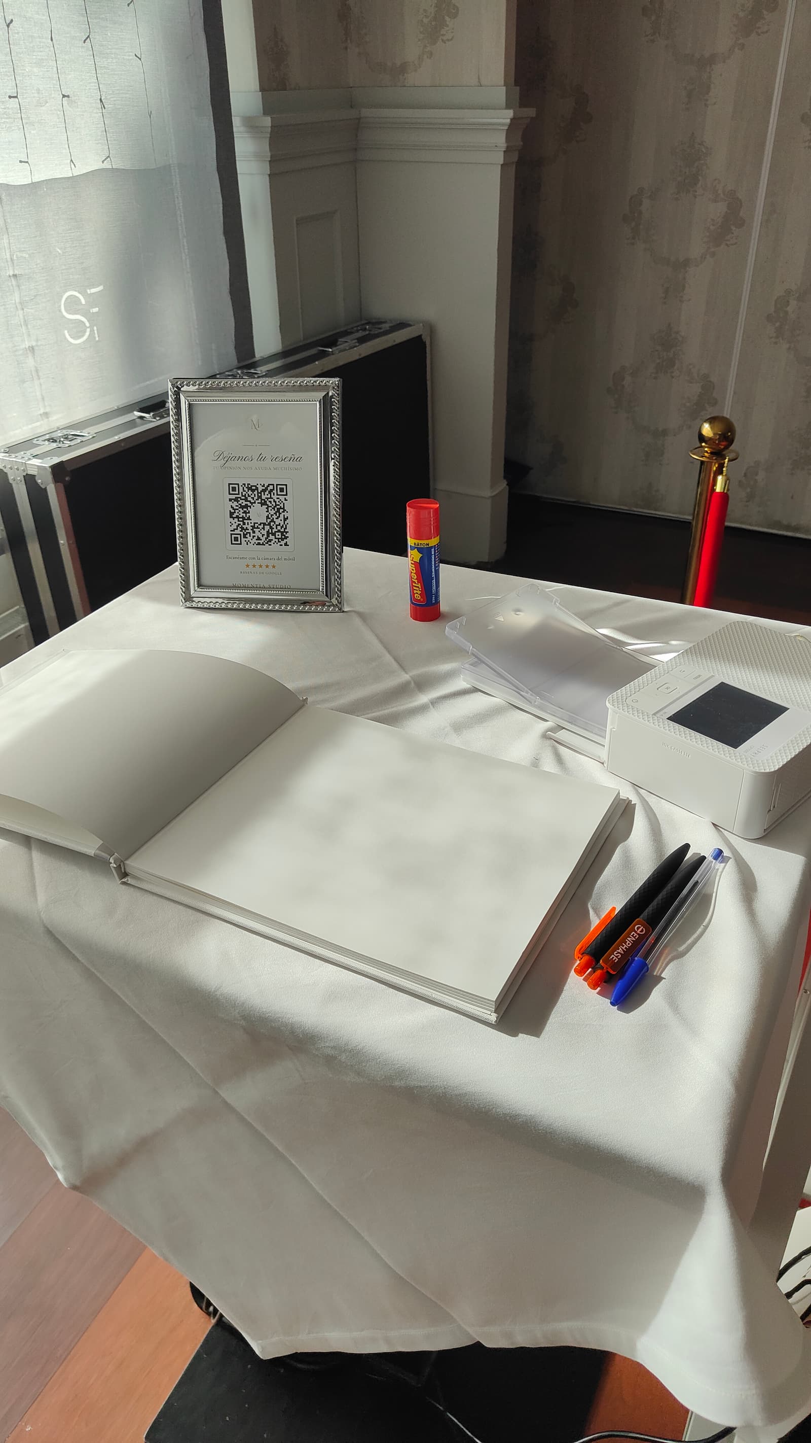 El álbum de firmas abierto sobre la mesa, con la impresora y los bolígrafos listos